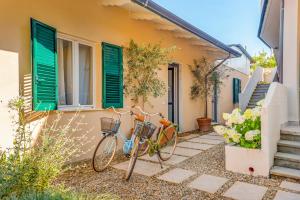 two bikes parked next to a building with green shutters at CasaMichelin in Marina di Massa
