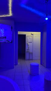 a blue room with a room with a table and a stool at Romantic Suite with Private Jacuzzi in Noyon