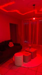 a red room with a couch and a table at Romantic Suite with Private Jacuzzi in Noyon