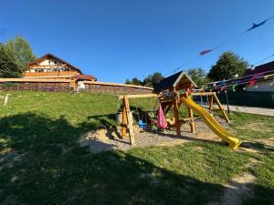 a park with a playground with a slide at Pensiunea Floare de Maramures in Vadu Izei
