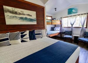 a bedroom with a bed and two chairs at Kalani Hawaii Private Lodging in Pupukea