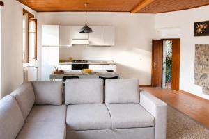 a living room with a couch and a kitchen at Panorama Lake Relax in Nesso +5 photos
