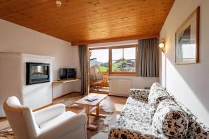 ein Wohnzimmer mit Sofa und Fernseher in der Unterkunft Hotel Frohnatur in Thiersee