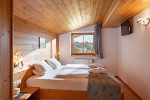 ein großes Bett in einem Zimmer mit Holzdecke in der Unterkunft Hotel Frohnatur in Thiersee + 49 Fotos