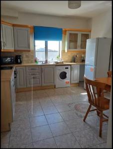 a kitchen with a white refrigerator and a window at Galway Break in Galway