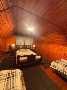 a room with two beds in a wooden cabin at Cabana Patru Anotimpuri in Rîmeţi