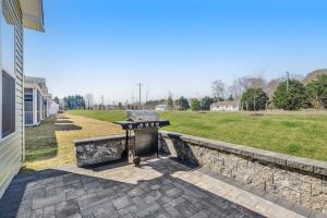 a barbecue grill sitting on a stone wall next to a yard at Bishop's Landing -- 31186 VICTOR RD in Millville
