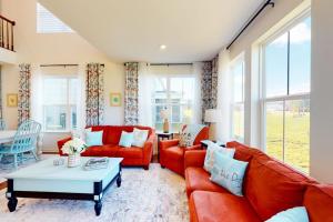 a living room with red couches and a table at Bishop's Landing -- 31186 VICTOR RD in Millville