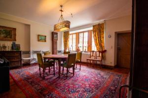 a dining room with a table and chairs on a rug at Gîte du Château de Spontin - 7a chaussée de Dinant - 5530 Spontin in Spontin