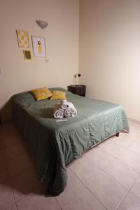 a bedroom with a bed with a green comforter at El Retorno Hostel in Puerto Madryn