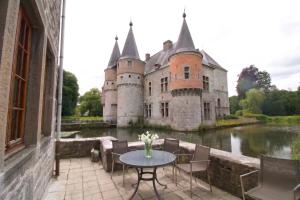a castle with a table in front of a river at Gîte du Château de Spontin - 7a chaussée de Dinant - 5530 Spontin in Spontin