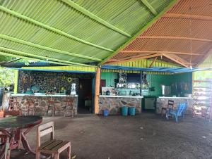 a room with tables and chairs and a kitchen at Kencho's Beach House-Sunset & Beachside stay in Ometepe in El Perú +30 photos