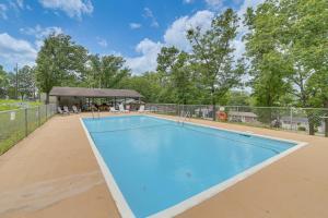 an empty swimming pool in front of a fence at Lakeside Reeds Spring Home w/ Deck & Pool Access! in Reeds Spring