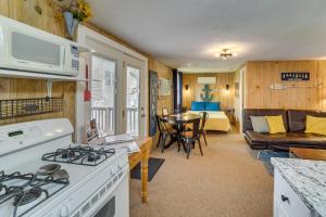 a kitchen and living room with a stove and a couch at Lakeside Reeds Spring Home w/ Deck & Pool Access! in Reeds Spring