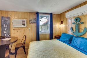 a bedroom with a bed and a table and a window at Lakeside Reeds Spring Home w/ Deck & Pool Access! in Reeds Spring