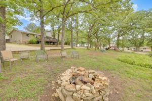 a fire pit in a park with chairs and trees at Lakeside Reeds Spring Home w/ Deck & Pool Access! in Reeds Spring