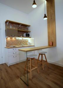 une cuisine avec une table en bois et deux tabourets dans l'établissement Apartment Old Zagreb, à Zagreb