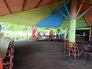 a group of tables and chairs in a building at Kencho's Beach House-Sunset & Beachside stay in Ometepe in El Perú