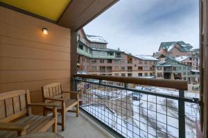 a balcony with two chairs and a view of a city at Zephyr Mountain Lodge Unit 1306 in Winter Park