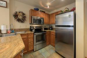a kitchen with stainless steel appliances and wooden cabinets at Zephyr Mountain Lodge Unit 1306 in Winter Park