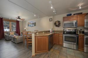 a kitchen with stainless steel appliances and a living room at Zephyr Mountain Lodge Unit 1306 in Winter Park +13 photos