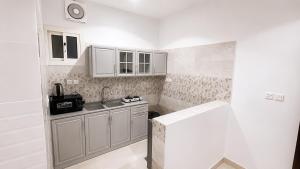 a small kitchen with white cabinets and a sink at أرياف سويت in Al Baha