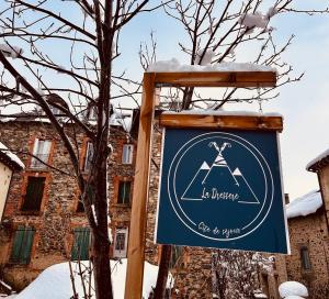 a sign in front of a building with snow on it at Gîte de séjour La Dressère in Formiguères