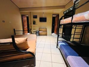 a room with two bunk beds and a room with a couch at Hospedaje Doña koko in Puerto Limón