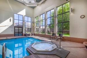 a large pool with a hot tub in a room with windows at Best Western Belleville in Belleville
