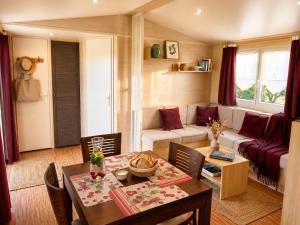 a living room with a table and a couch at Les Chênes verts in Saint-Savinien +33 photos