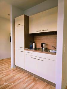 a kitchen with white cabinets and a sink at Nürnberg Nähe Studio in Fürth