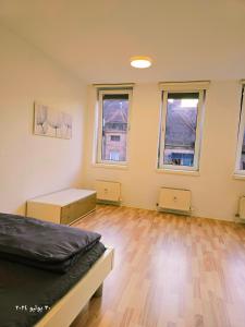 a large room with a bed and two windows at Nürnberg Nähe Studio in Fürth