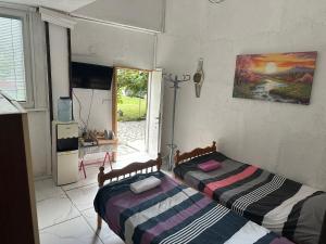 two beds in a room with a window at Rooms Struga free parking quiet area in Struga +289 photos
