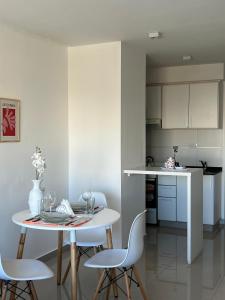a white kitchen with a table and chairs in a room at Blandengues 55 in Bahía Blanca