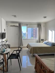 a bedroom with a bed and a table and chairs at Blandengues 55 in Bahía Blanca