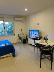 a bedroom with a bed and a table and a tv at Blandengues 55 in Bahía Blanca