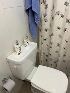 a bathroom with a toilet and a shower curtain with umbrellas at Blandengues 55 in Bahía Blanca +80 photos