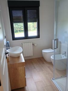 a bathroom with two sinks and a toilet and a window at A de Amancio in Sayáns +61 photos