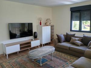 a living room with a couch and a flat screen tv at A de Amancio in Sayáns