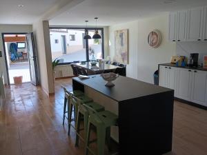 a kitchen with a black island and chairs in a room at A de Amancio in Sayáns