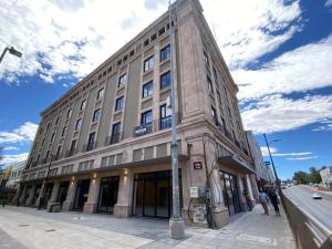 ein großes Gebäude an einer Stadtstraße mit einem Mast in der Unterkunft Chihuahua Historic Suite in Chihuahua