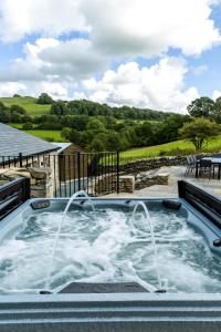 a jacuzzi tub with two faucets in the middle at Thornyfield Barn in Winster