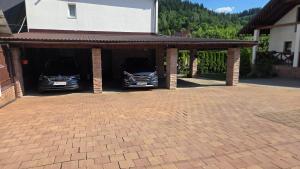 two cars are parked in a car garage at Ubytovanie u Adama in Oščadnica