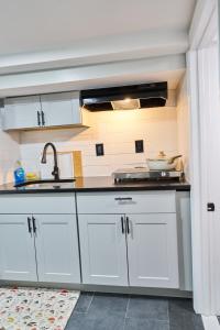 a kitchen with white cabinets and a sink at Joynest Nest - Private Entry & Bath in Newark