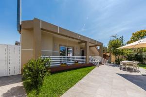 a house with a patio and an umbrella at Oasis Paradise Pool Villa in Durrës