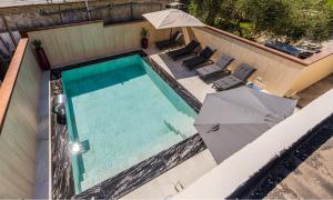 an overhead view of a swimming pool with an umbrella and chairs at Oasis Paradise Pool Villa in Durrës