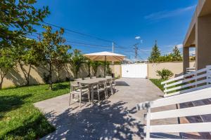 a patio with a table and an umbrella at Oasis Paradise Pool Villa in Durrës