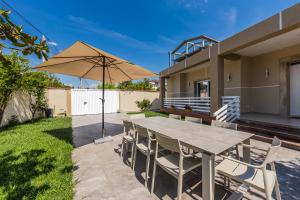 a patio with a table and an umbrella at Oasis Paradise Pool Villa in Durrës
