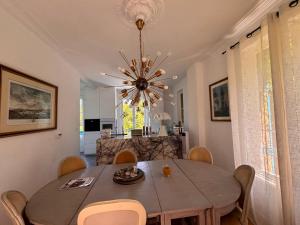 a dining room with a table and a chandelier at La maison de Blandine in Honfleur