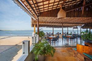 a restaurant on the beach with tables and chairs at Vila Gallina Pousada in Jericoacoara